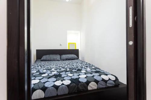 une chambre avec un lit avec une couette noire et blanche dans l'établissement FEEL HOME - FRANCE 15, à Nice