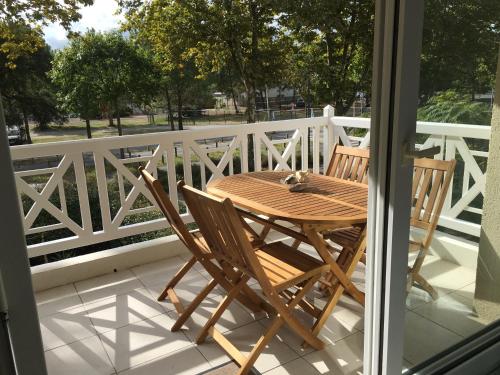 drewniany stół i krzesła na balkonie w obiekcie Appartement T2 ocean location week-end 3 nuits hors saison avec terrasse et parking 200 m de la plage w mieście Moliets-et-Maa