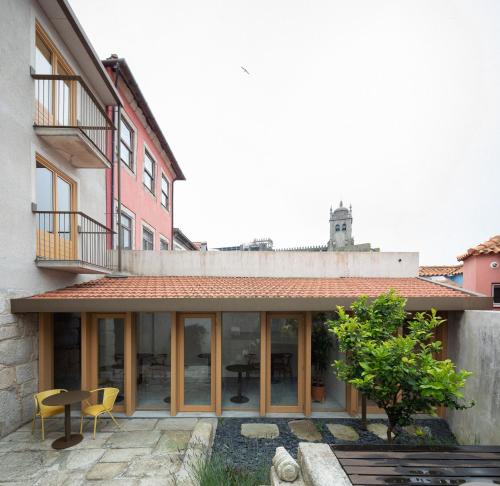 an external view of a building with windows and a patio at Na Travessa Suítes in Porto