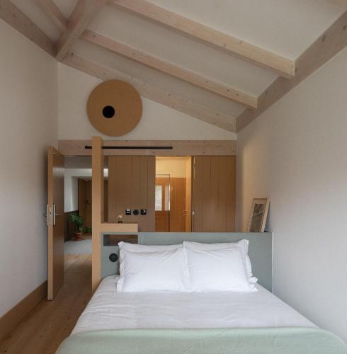 a bedroom with a large bed with white sheets at Na Travessa Suítes in Porto