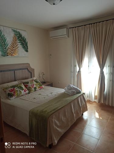 貝瑙漢的住宿－Vivienda Domínguez Sánchez，一间卧室设有一张床和一个大窗户