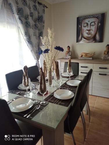 a dining room table with plates and vases on it at Vivienda Domínguez Sánchez in Benaoján