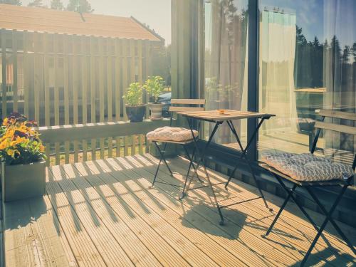 a patio with two tables and two chairs on a balcony at Green Valley vacation homes in Žocenes Ciems