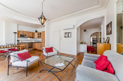 - un salon avec deux canapés et des oreillers rouges dans l'établissement Appartement de grand standing, joliment décoré, à Marseille