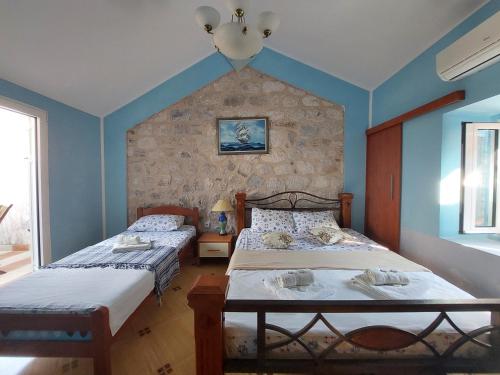 - 2 lits dans une chambre aux murs bleus dans l'établissement Apartments Jelena, à Kotor