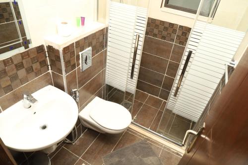 a bathroom with a toilet and a sink at AlQimah Hotel Apartments in Amman