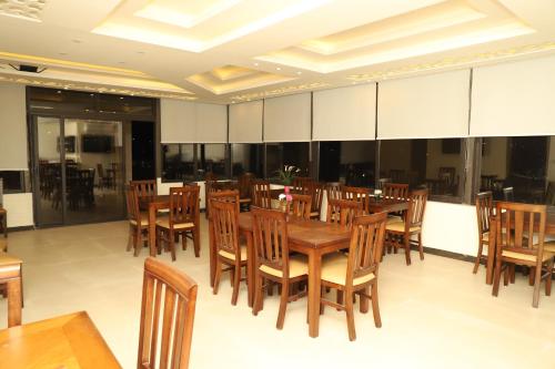 a dining room with wooden tables and chairs at AlQimah Hotel Apartments in Amman