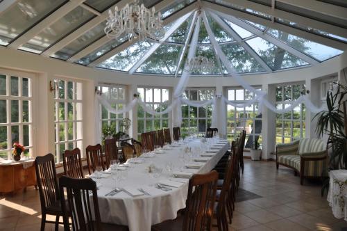 einen langen Tisch in einem Zimmer mit einem Kronleuchter in der Unterkunft Restauracja - Hotel Pałacowa in Rogowo