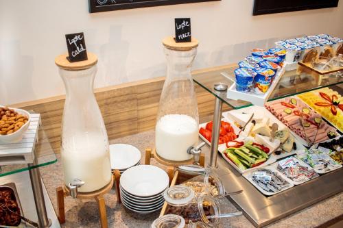 two tall bottles of milk sitting on top of a buffet at RIVER Hotel & SPA in Călimăneşti