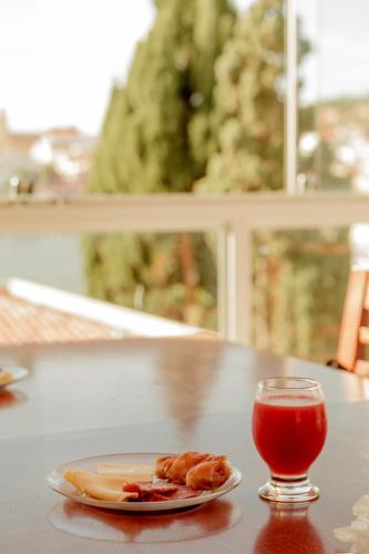 a plate of food and a drink on a table at Pousada Alpes in Triunfo