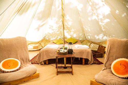 a tent with two beds and a table in a room at DGG Woodland Escape in South Barrow