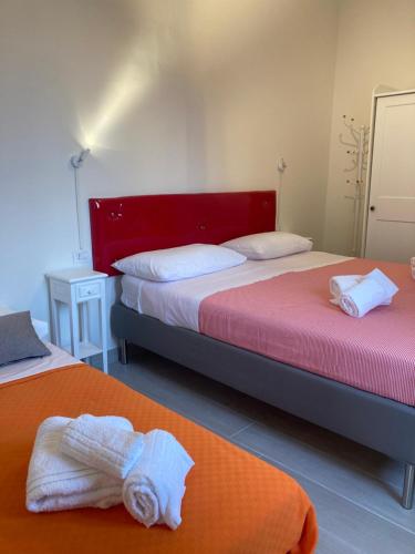 um quarto com 2 camas e toalhas em Casa Donna Francy City Center em Nápoles