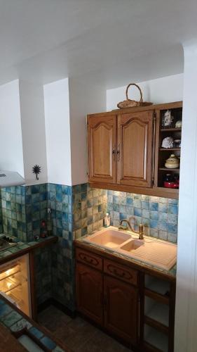une cuisine avec des armoires en bois et un évier dans l'établissement APT FRONT DE MER DANS RESIDENCE LUXE SECURISEE, à Banyuls-sur-Mer