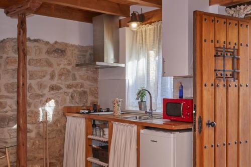 cocina con fregadero y microondas rojo en La Pequeña Luz Casa Rural, en Tabanera de Cerrato