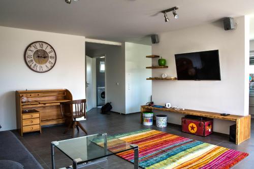 a living room with a clock on the wall at Alpenblick 2 in Lindau-Bodolz