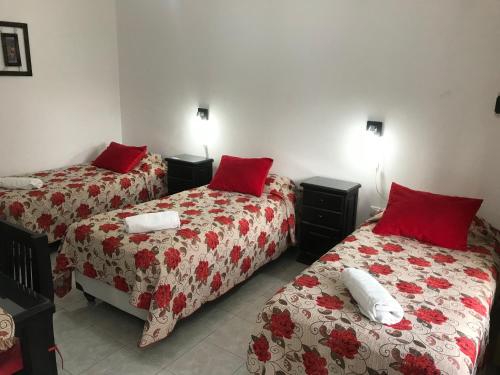 two beds in a room with red pillows on them at Cabaña La Martina in Chilecito