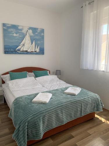 a bedroom with a large bed with two towels on it at Apartmani Paula in Vodice