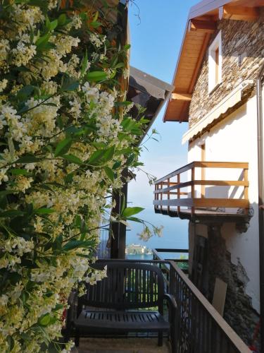 a balcony with a bench and flowers at Casa Orfea in Stresa