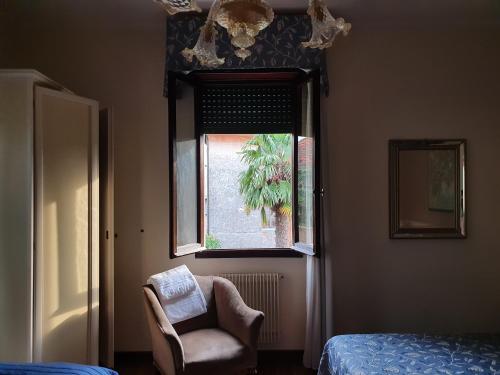 um quarto com uma cadeira e uma janela em villa berghinz em Veneza-Lido