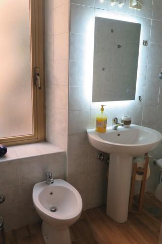 uma casa de banho com um lavatório, um WC e um espelho. em Room CasaVostrA em Roma