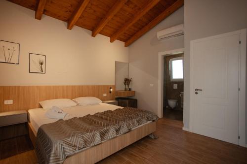 a bedroom with a large bed and a bathroom at Premium Villas Resort in Shëngjin