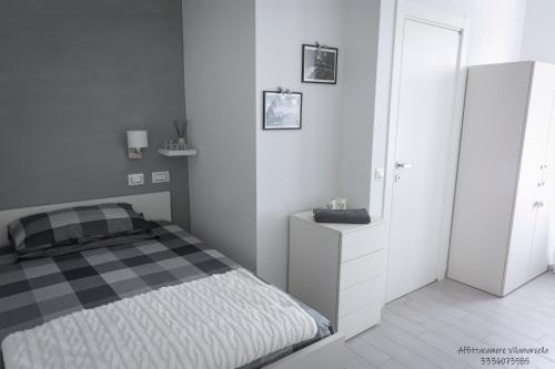 a white bedroom with a bed and a white cabinet at Affittacamere Villa Marcella in La Spezia