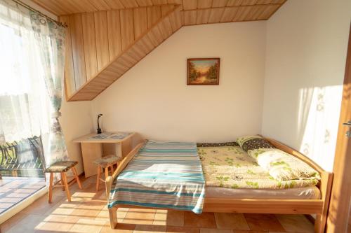 a bedroom with a bed in a room with windows at Pokoje Gościnne Martynka in Białogóra
