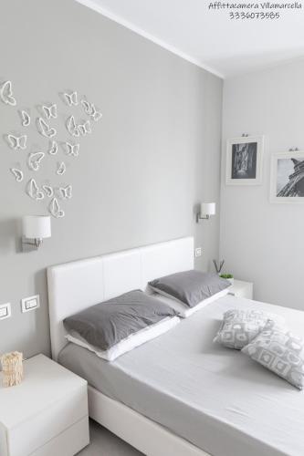 two beds in a white bedroom with white walls at Affittacamere Villa Marcella in La Spezia