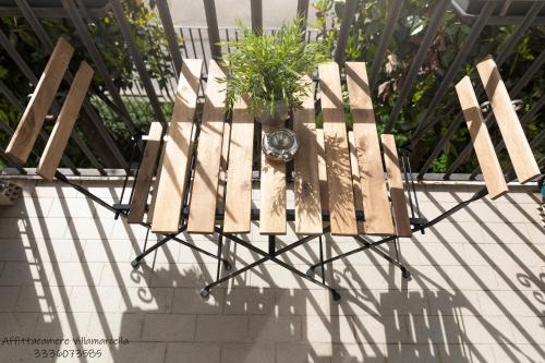 a wooden bench with a potted plant on it at Affittacamere Villa Marcella in La Spezia