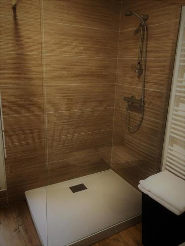 a shower with wooden walls and a glass door at Les oiseaux de la Slack in Ambleteuse