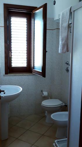 サン・ヴィート・ロ・カーポにあるAppartamento Lunaのバスルーム(洗面台、トイレ付)、窓が備わります。
