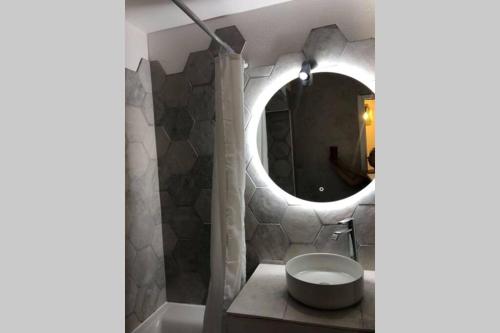 a bathroom with a round mirror and a sink at L'orée des Pins TROPICO Appartement T2 en RDC avec terrasse refait à neuf in Lacanau