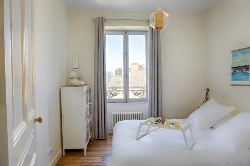 a white bedroom with a bed and a table at Résidence L'Aristide : Appartement Malo in Auray