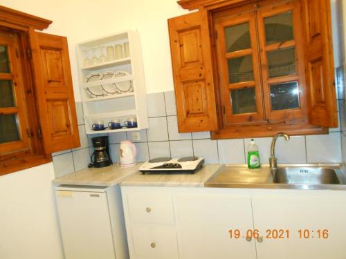 a kitchen with wooden cabinets and a sink at PATMOS Mathios Studios- apartments in Patmos