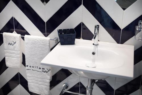 a bathroom with a sink and towels on a wall at Positamy in Positano