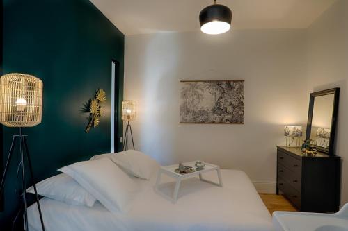 a bedroom with a white bed and a table at Résidence l'Aristide : Appartement Naomi in Auray