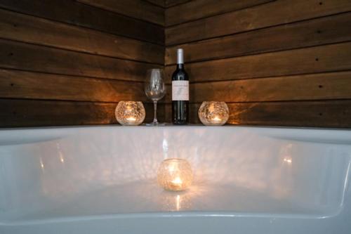 uma banheira com uma garrafa de vinho e 2 copos em A Casa Branca em Santa Comba Dão