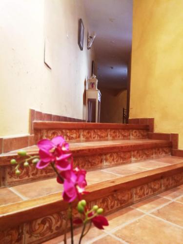 a church altar with a purple flower in the foreground at Casa Rural El Infante in Oropesa