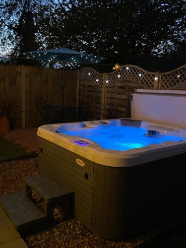 a jacuzzi tub in a backyard at night at Saving Grace with private hot tub in Bawdeswell