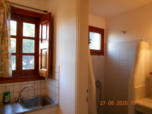a bathroom with a sink and a window at PATMOS Mathios Studios- apartments in Patmos