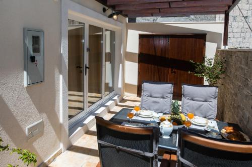 eine Terrasse mit einem Tisch und Stühlen auf dem Balkon in der Unterkunft House Andro in Primošten