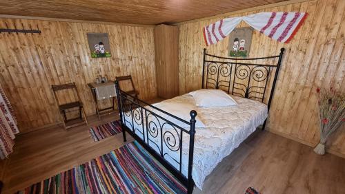 una camera con un letto in una stanza con pareti in legno di Lângă Stână a Curtea de Argeş