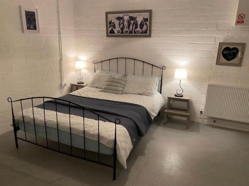 1 dormitorio con 1 cama grande y 2 lámparas en Mill House Studio Apartment, en Stranocum