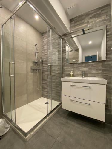 une salle de bain avec une douche, un lavabo et un miroir dans l'établissement Appartement calme avec terrasse proche du centre ville et de la mer, parking, internet, à Bastia