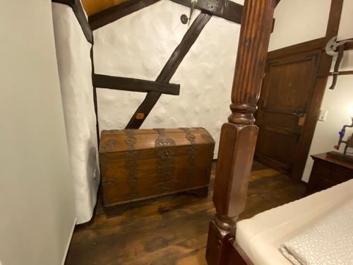 an old wooden trunk sitting in the corner of a room at Fewo WAFFENKAMMER im Rittergut Leppersdorf bei Dresden für 7 Personen in Leppersdorf