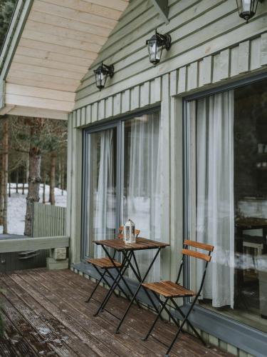a table and chairs on the porch of a house at Green Valley vacation homes in Žocenes Ciems