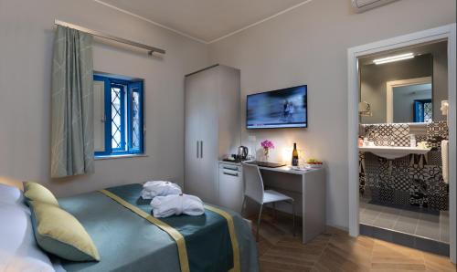 sypialnia z łóżkiem i biurkiem oraz łazienka w obiekcie Casa Blandano B&B w mieście Castelmola