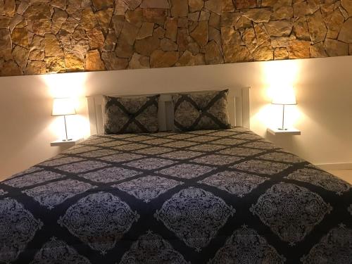 a bedroom with a bed with two lamps on both sides at Casa da Aldeia in Tomar