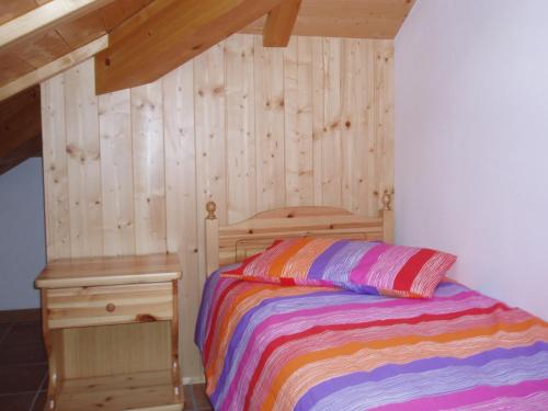 Un dormitorio con una cama y una pared de madera. en Agritur Melango, en Fondo