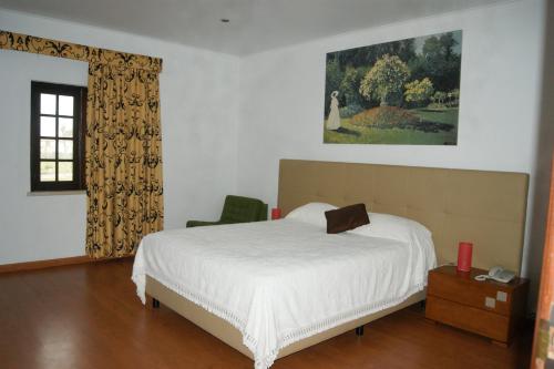 a bedroom with a white bed and a window at Hotel Rural A Coutada - Peniche in Atouguia da Baleia